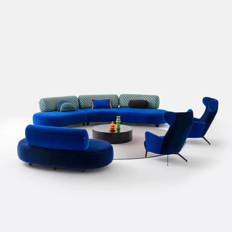 Circular blue velvet sectional sofa set with modern round coffee table on white background by LEOPARD Furniture Canada.