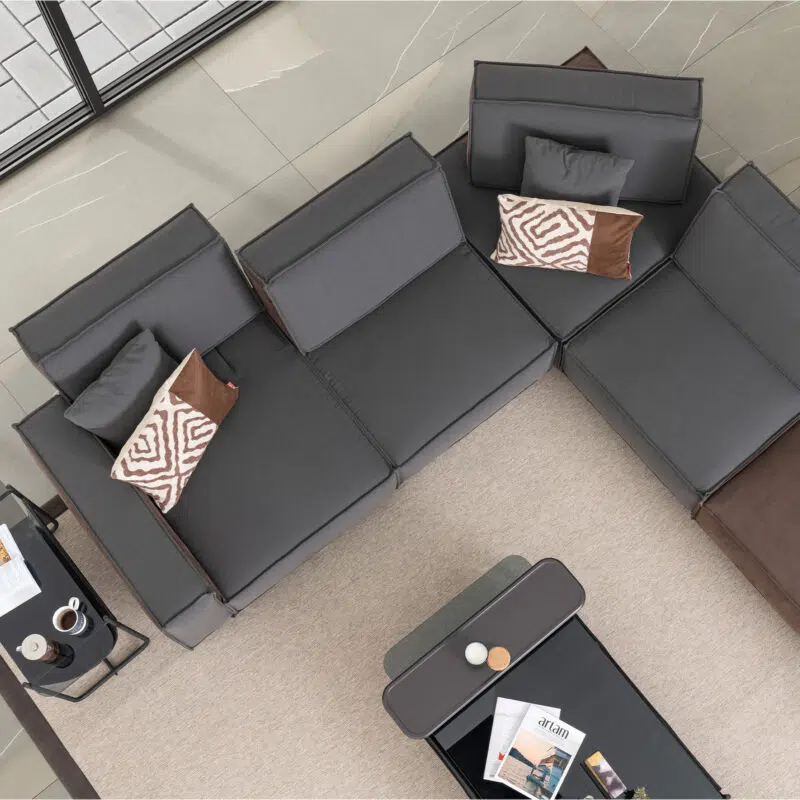 Sectional grey sofa with patterned cushions in modern living room setup at LEOPARD Furniture, Canada.