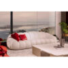 Luxurious white curved sofa with red cushions in a modern living room overlooking the ocean - LEOPARD Furniture Canada.