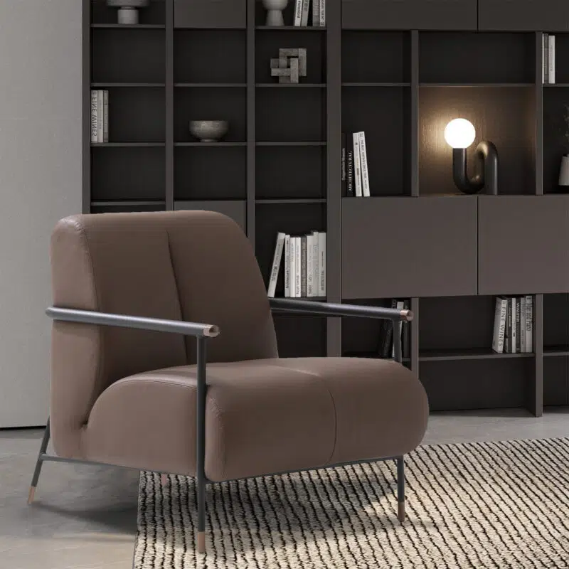 Elegant armchair en cuir brun, design moderne, devant une bibliothèque sombre. Luxe intérieur par LEOPARD Furniture Canada.