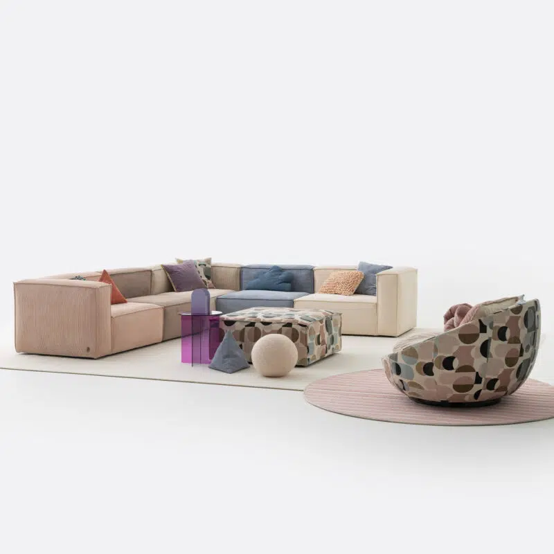 Ensemble de salon moderne avec canapé modulaire LEOPARD et pouf géométrique sur fond blanc.