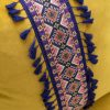 Coussin en velours jaune avec broderie ethnique colorée et franges. Design exclusif LEOPARD Furniture Canada.