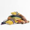 Pile de coussins bohèmes à motifs colorés sur fond blanc, LEOPARD Furniture Canada.
