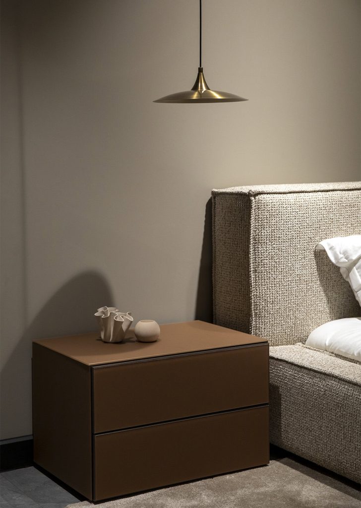 Modern minimalist bedside table with beige textured bed, pendant lamp, and decor in a stylish room by LEOPARD Furniture.